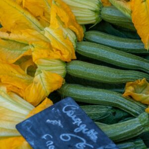 a box filled with cucumbers and yellow flowers